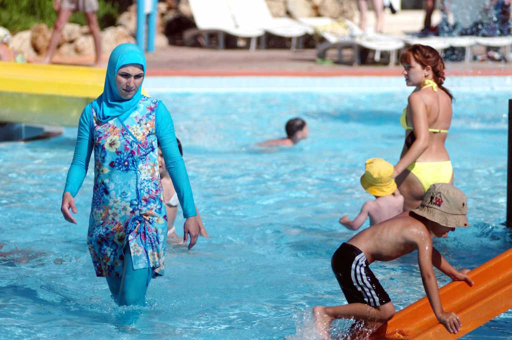 Woman wearing islamic swimsuit at the Aqualand's swimming pool in Antalya. Antalya, TURKEY- Burkini